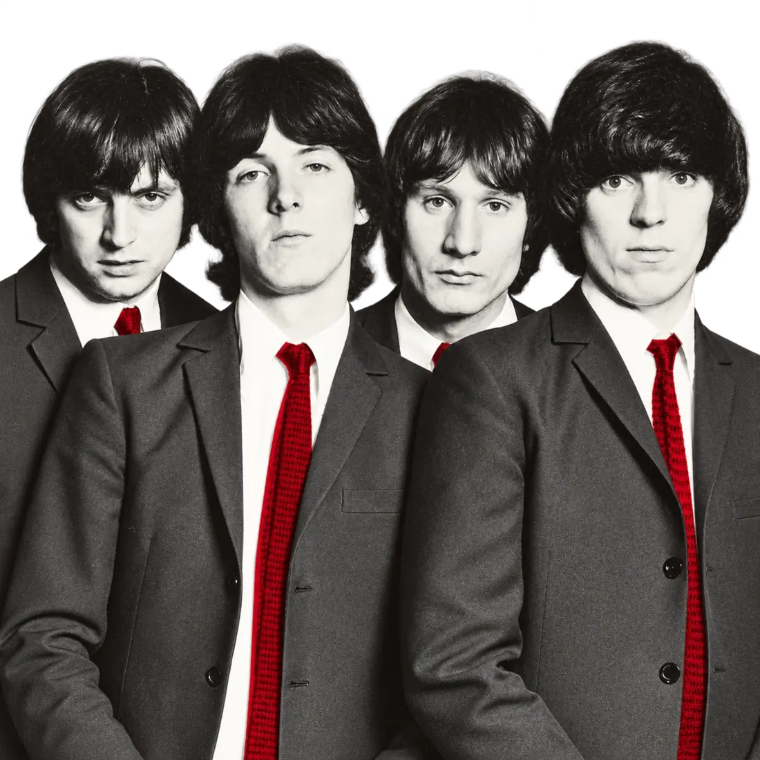 The Pleasers in matching suits gathered around a studio camera